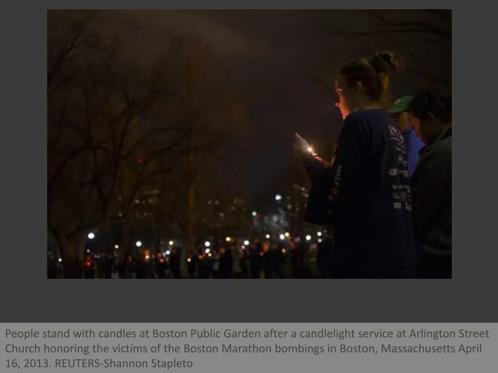 people stand with candles at boston public garden