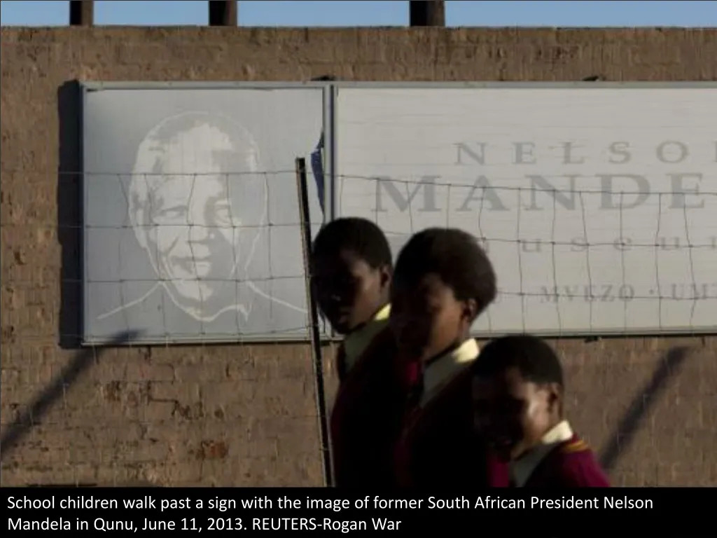 school children walk past a sign with the image