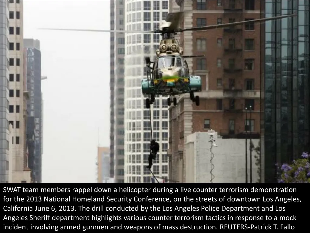 swat team members rappel down a helicopter during