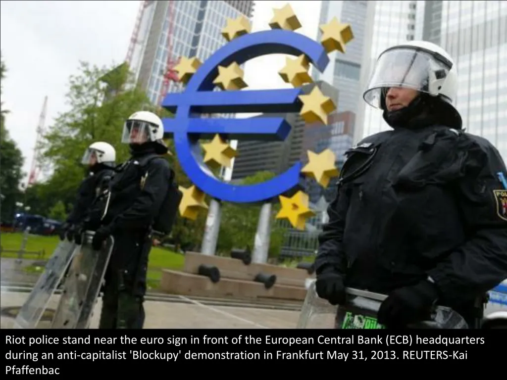 riot police stand near the euro sign in front