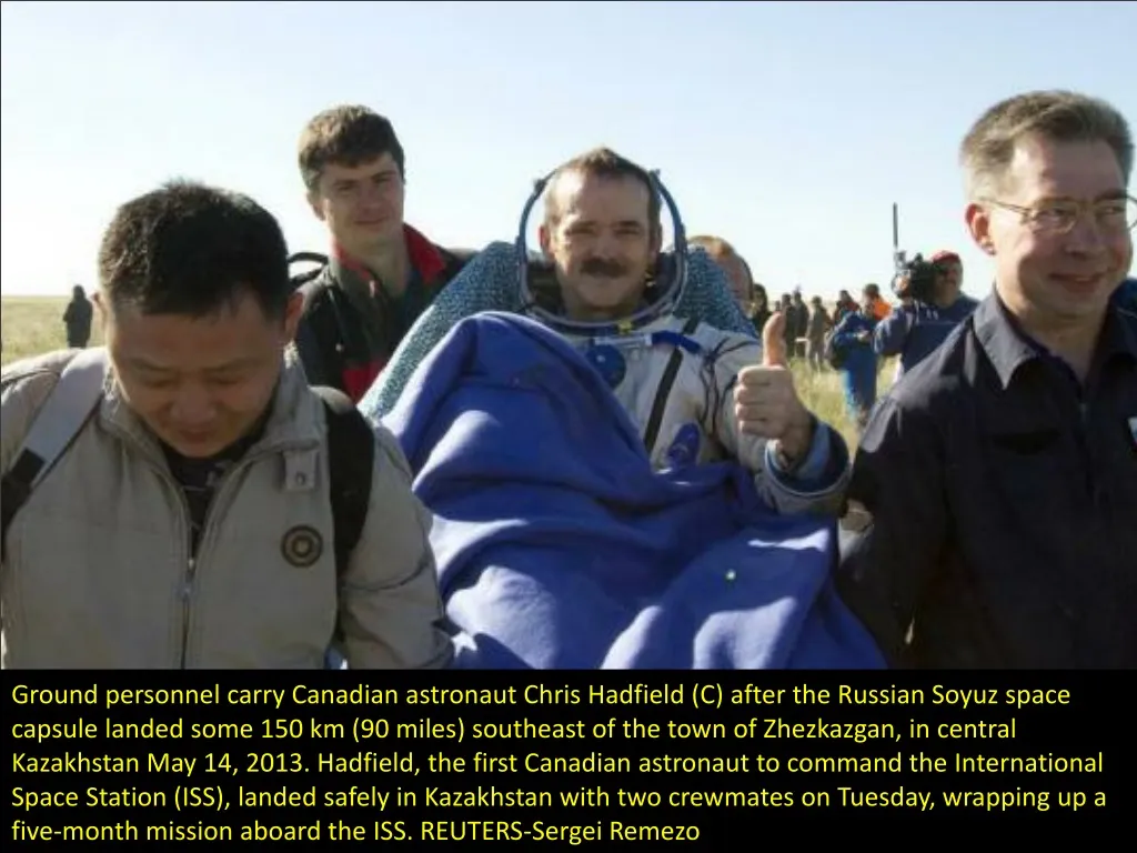 ground personnel carry canadian astronaut chris