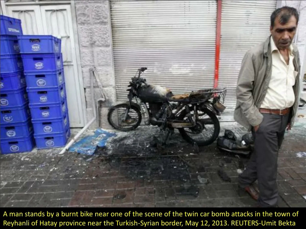 a man stands by a burnt bike near