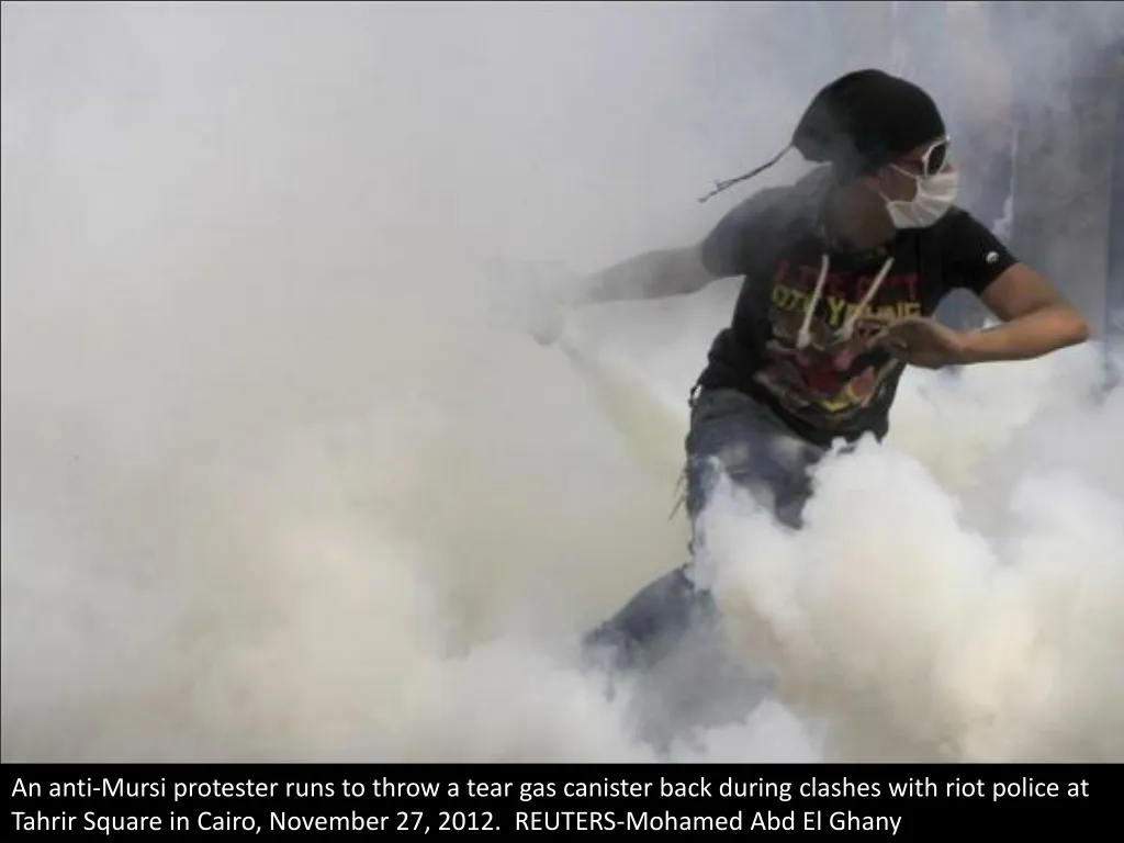 an anti mursi protester runs to throw a tear