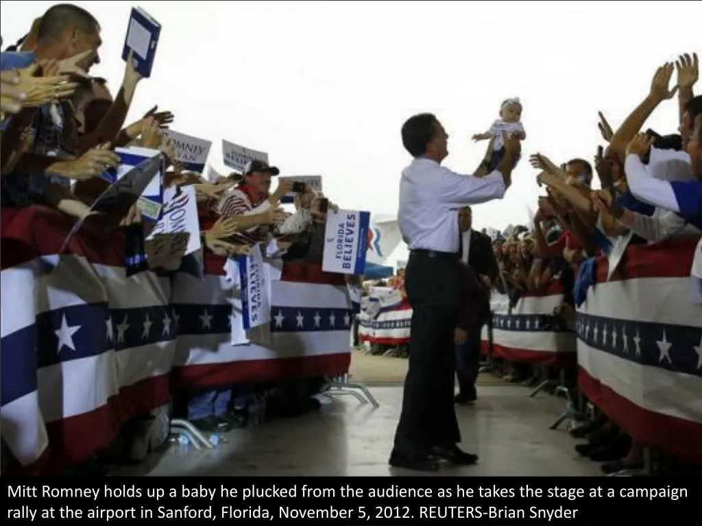 mitt romney holds up a baby he plucked from