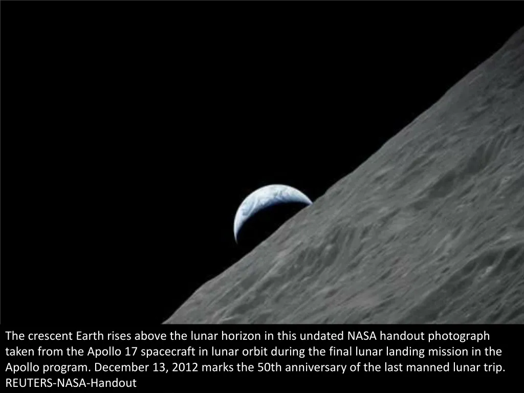 the crescent earth rises above the lunar horizon