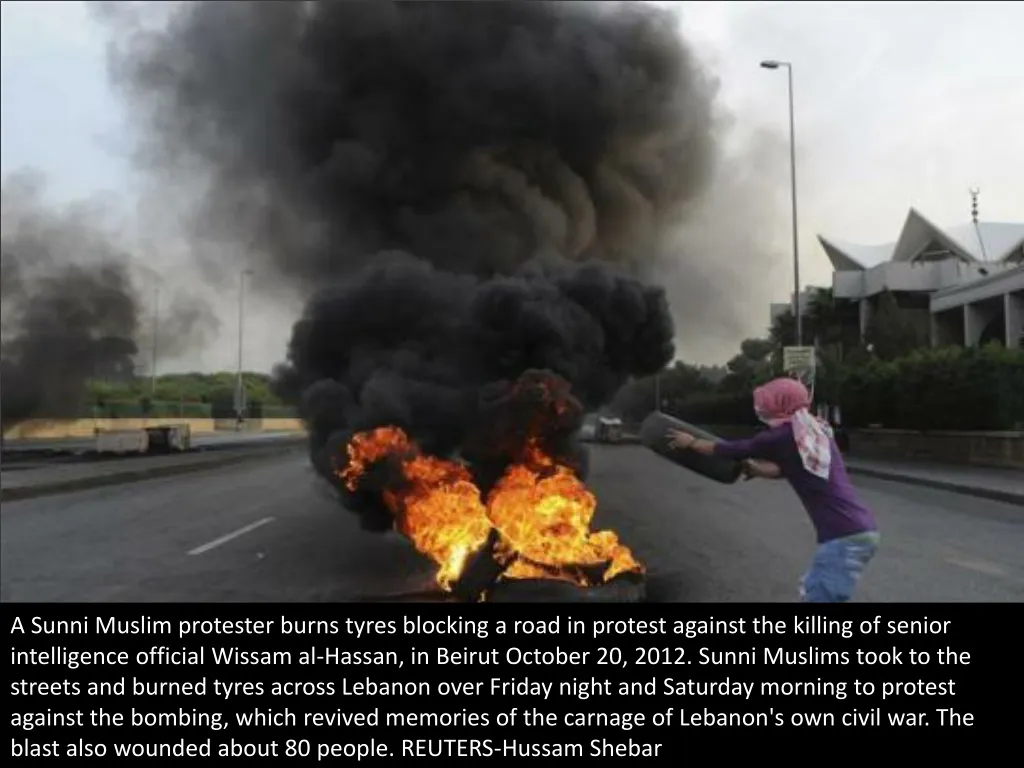 a sunni muslim protester burns tyres blocking