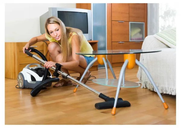 Woman Using A Canister Vacuum to Clean Hardwood Floor